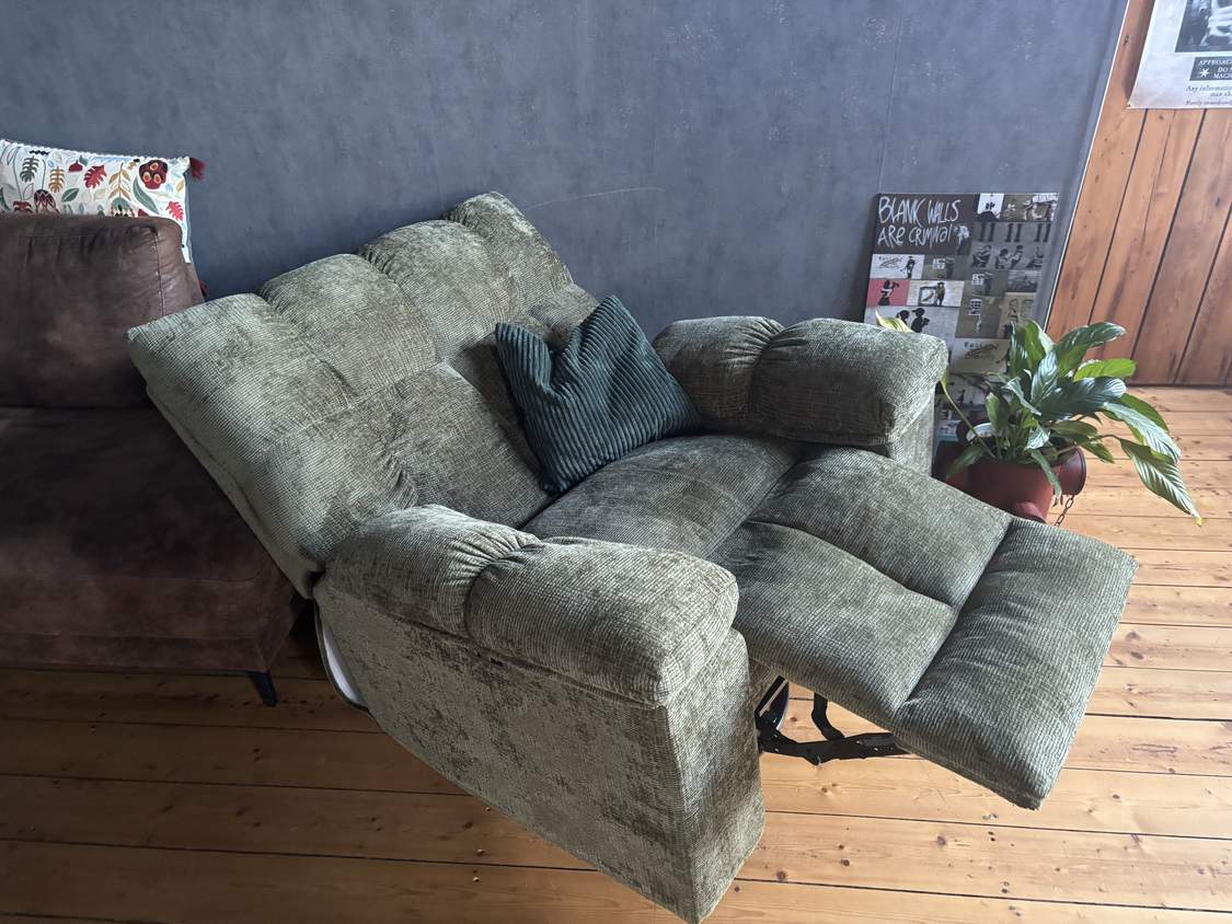 FlexiSpot Waffle Relaxsessel im Wohnzimmer neben einem Sofa, in ausgefahrener Liegeposition auf Holzdielen
